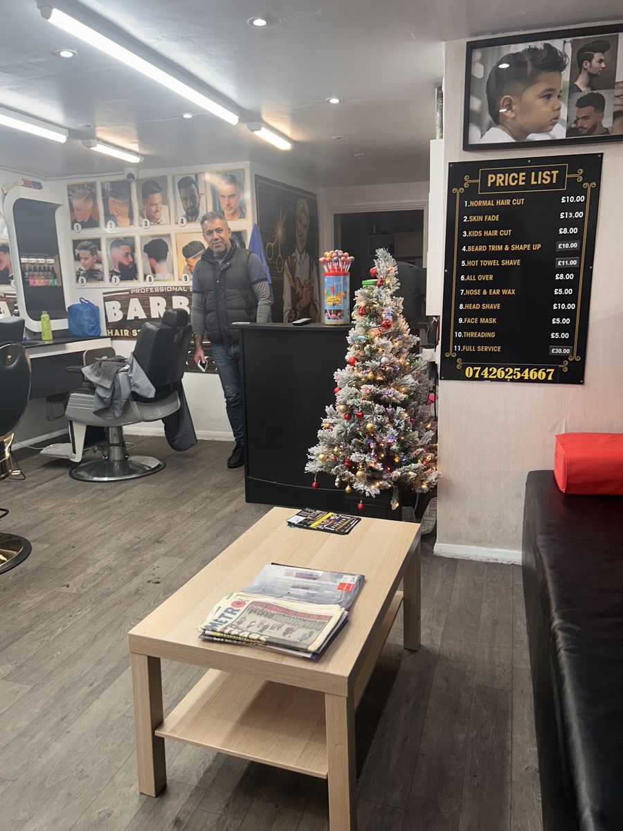 Waiting area with the price list and a wall of haircut photos