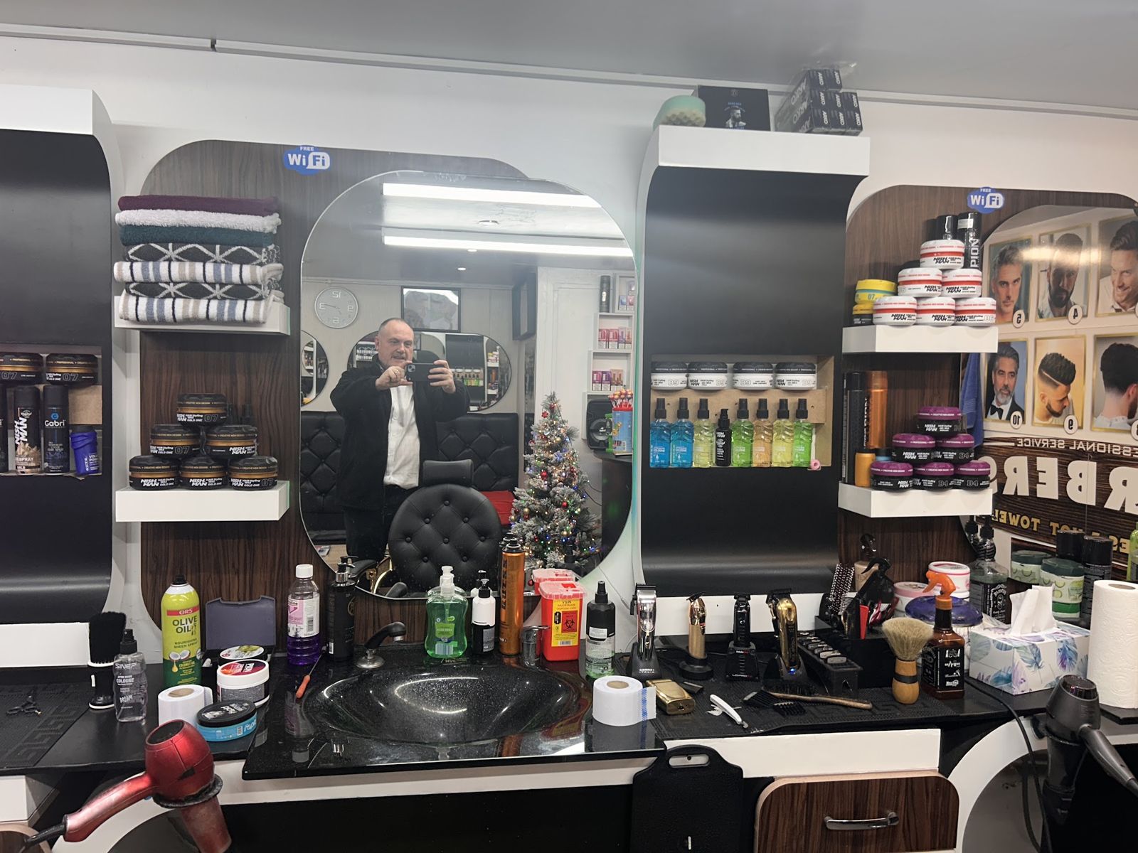Mirror stations stocked with clippers, pomades and hair products